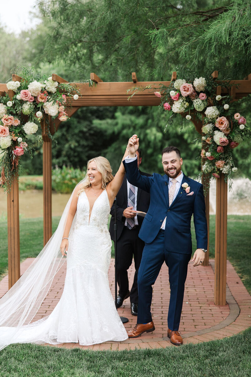 Bride and Groom standing under a covered Bridge kissing