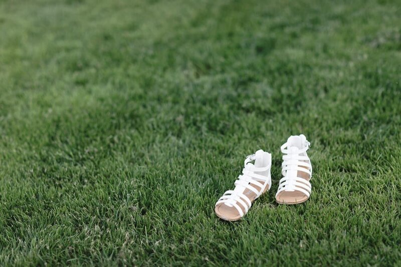 Shoes of a flower girl on a lawn