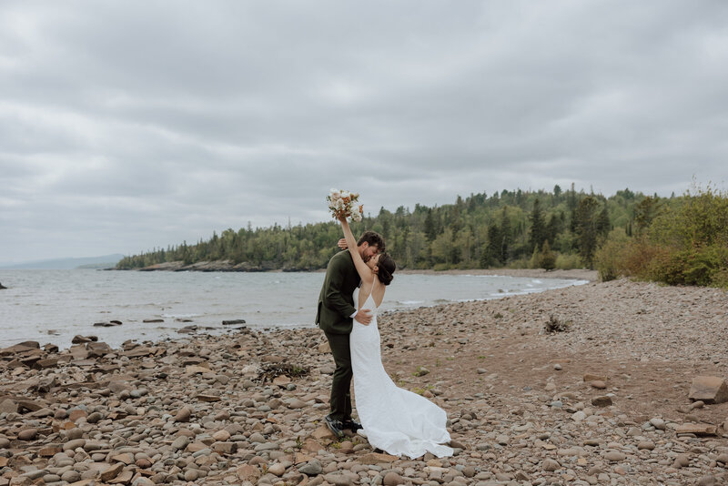 bride and groom embracing on a beach on the north shore of minnesota. Captured by a north shore elopement photographer