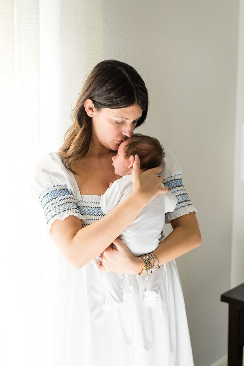 Mother cuddling newborn baby during an in-home photography session in Austin, TX