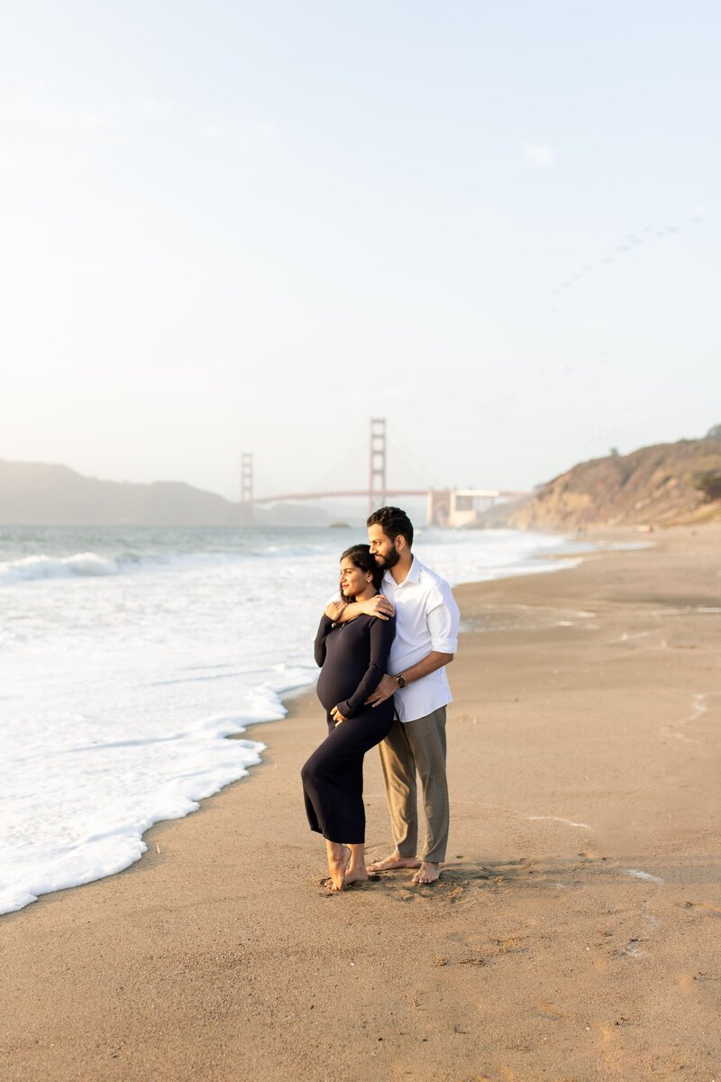 Pregnant woman and husband in front of the golden gate bridge