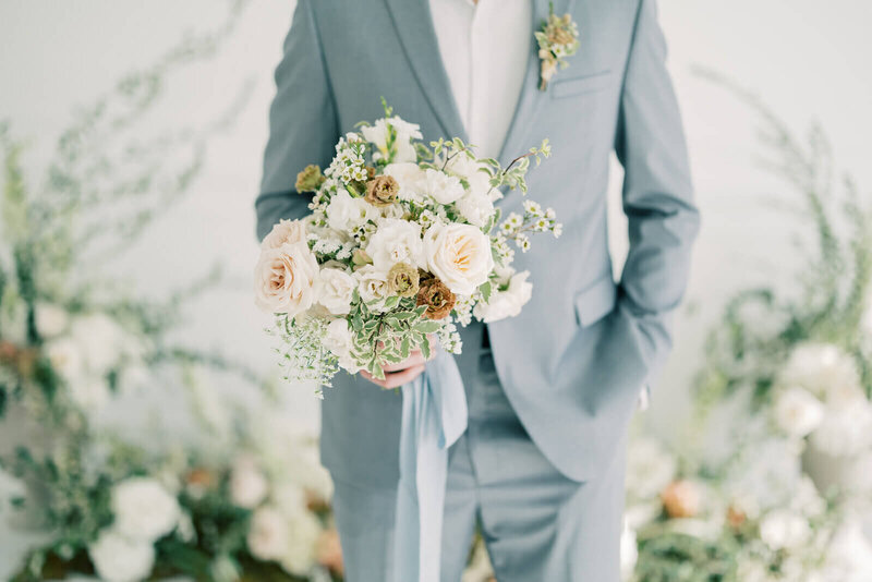 groom holding bouquet by wedding planner Minnesota