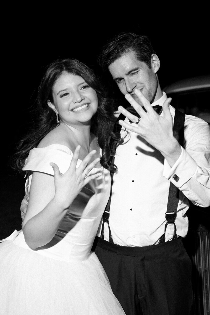 Bride and groom showing off their new wedding bands at their reception inside the Rosecliff Mansion in Newport, RI, photographed by Andrea-Marie Photography