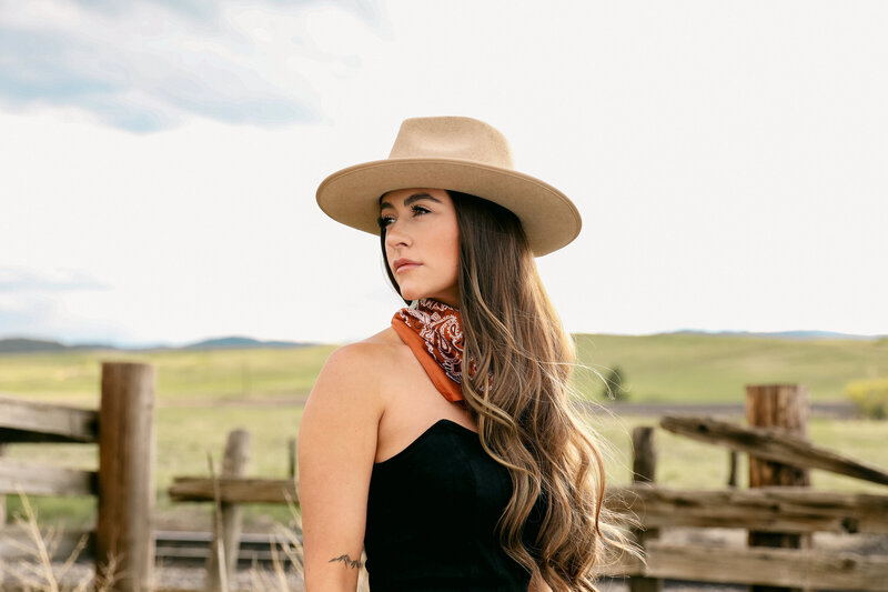 Western-styled senior girl in a rustic location at sunset in Colorado