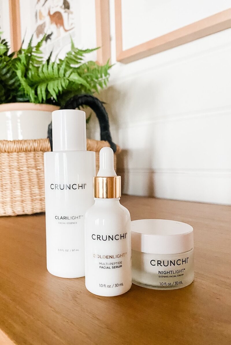 Image of Crunchi skincare products sitting on a dresser by a plant.