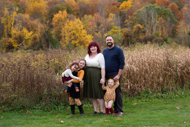 A family of 5 posing for their fall family photoshoot.
