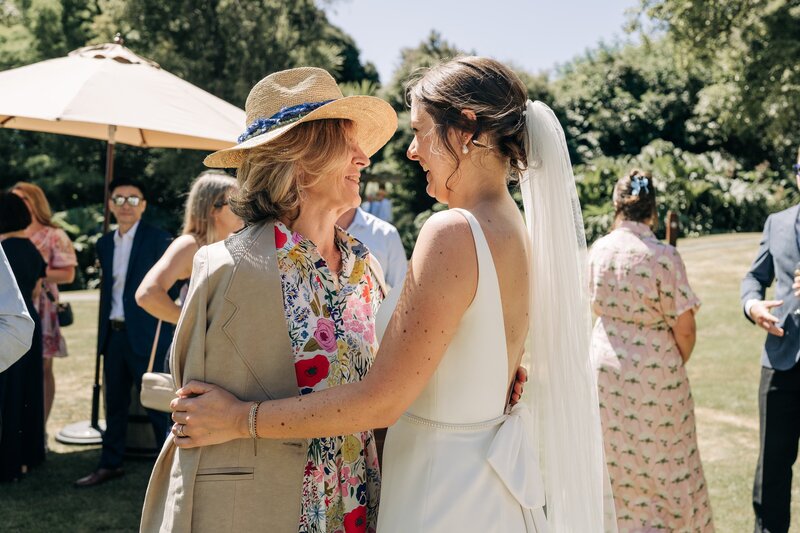 candid photo of bride hugging wedding guest in akaroa