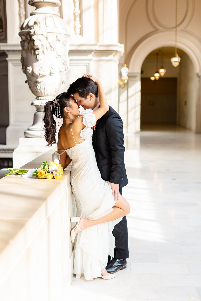 Couple kissing on the fourth floor of San Francisco City Hall after getting married. 