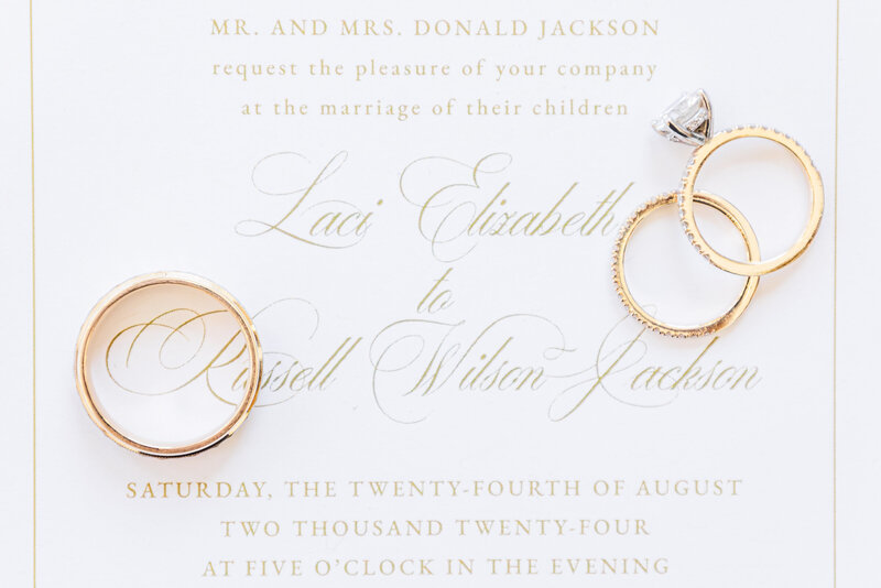 wedding rings on top of a wedding invitation