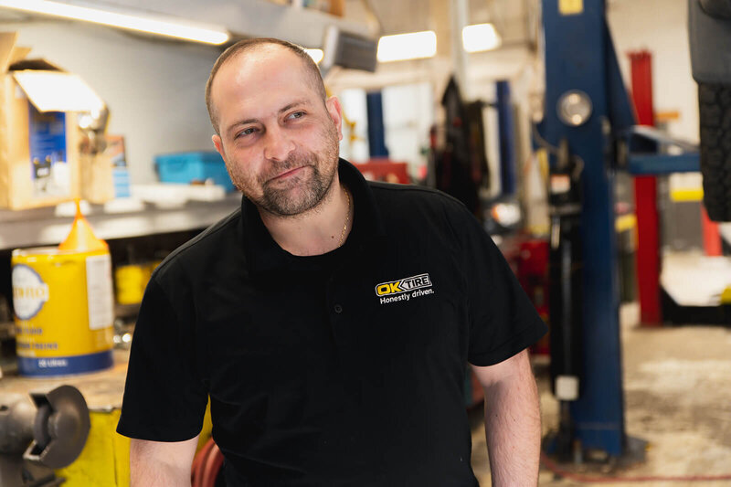 Automotive mechanic smiling in automotive shop