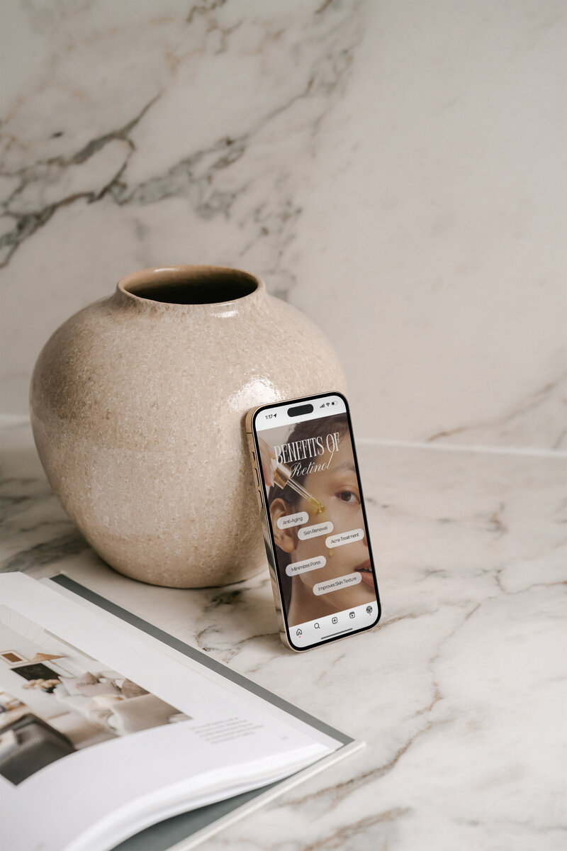 Phone showing Instagram story leaning on flower vase on marble table