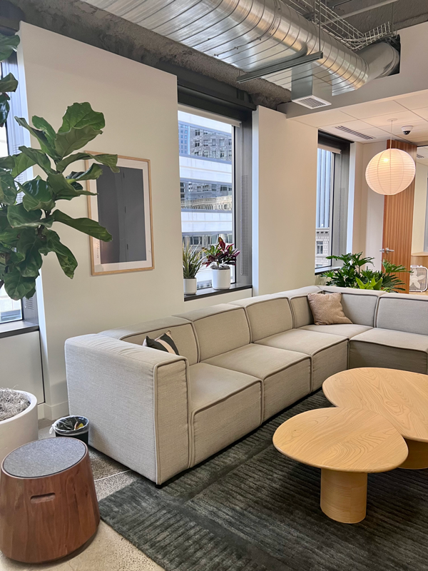 Julius office lounge area with L-shape couch and modern wooden coffee table