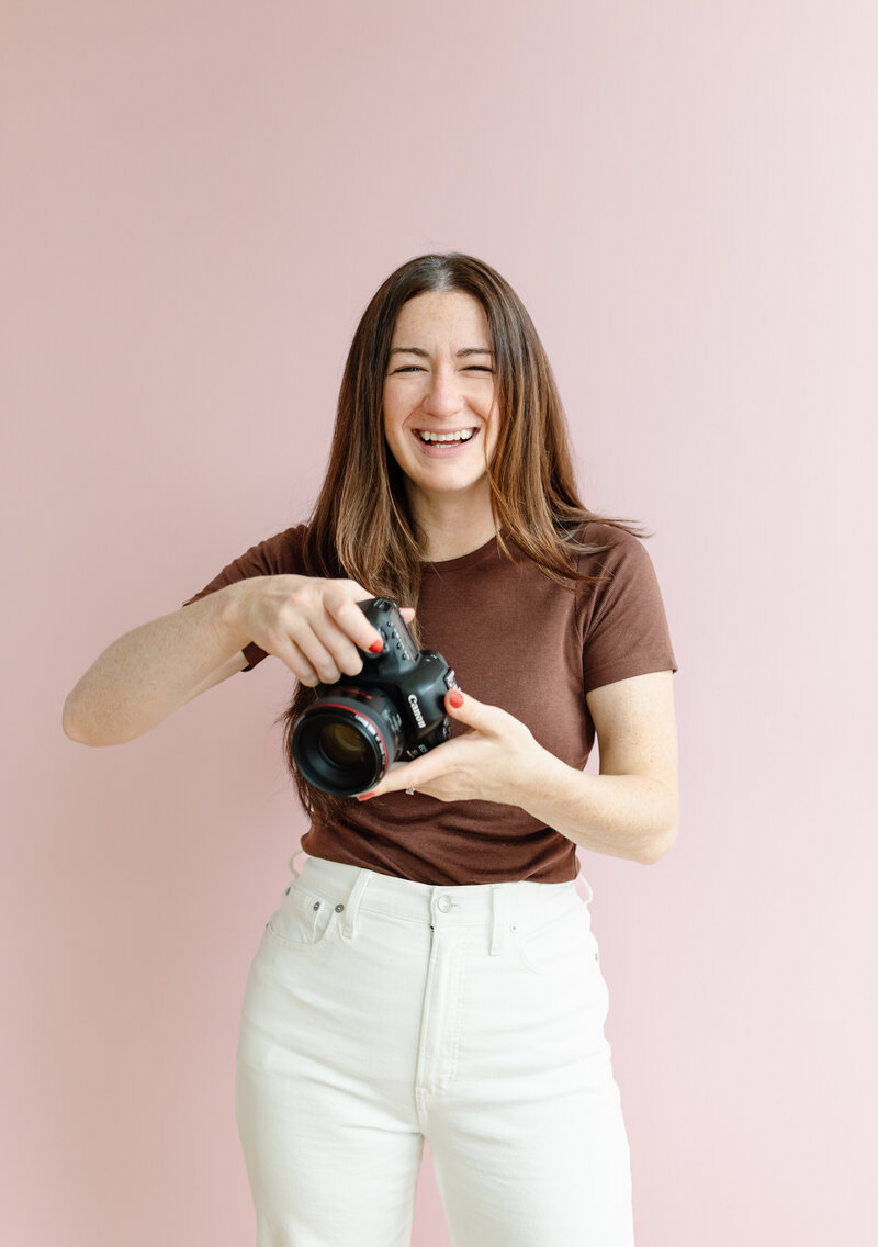 Branding photo of Melissa Stuckey standing holding a camera