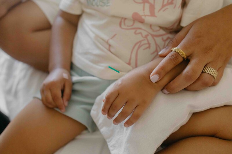 Main d’un enfant recevant une aiguille d’acupuncture