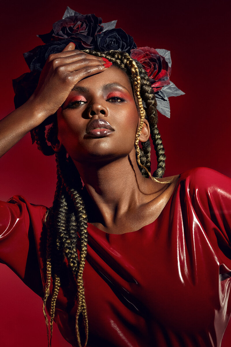 Stylish portrait of Lilian in a red outfit with intricate accessories and makeup, captured by Ylva Erevall.