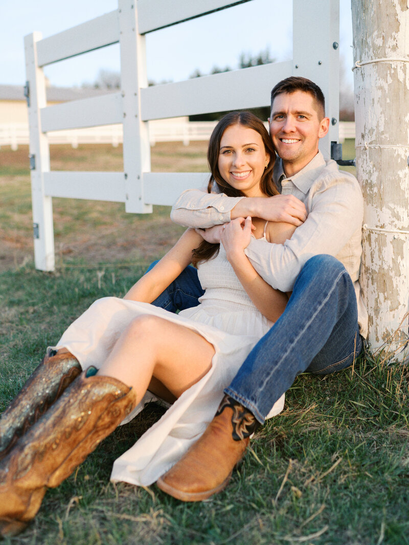 couple-sitting-against-fence-post