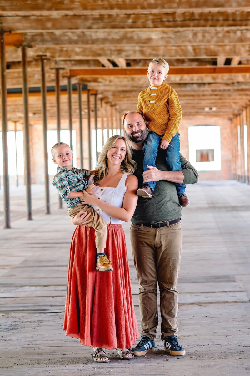 Family of four smiling during an industrial location portrait session