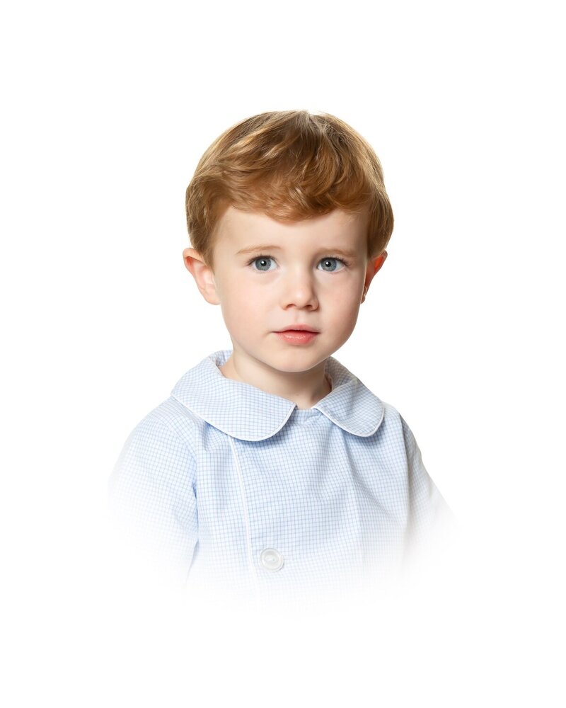 Timeless heirloom portrait of a young boy in a peter pan collar, captured with studio lighting against a classic white backdrop