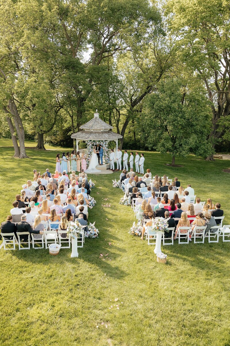 A ceremony held at a gazebo at a garden party wedding.