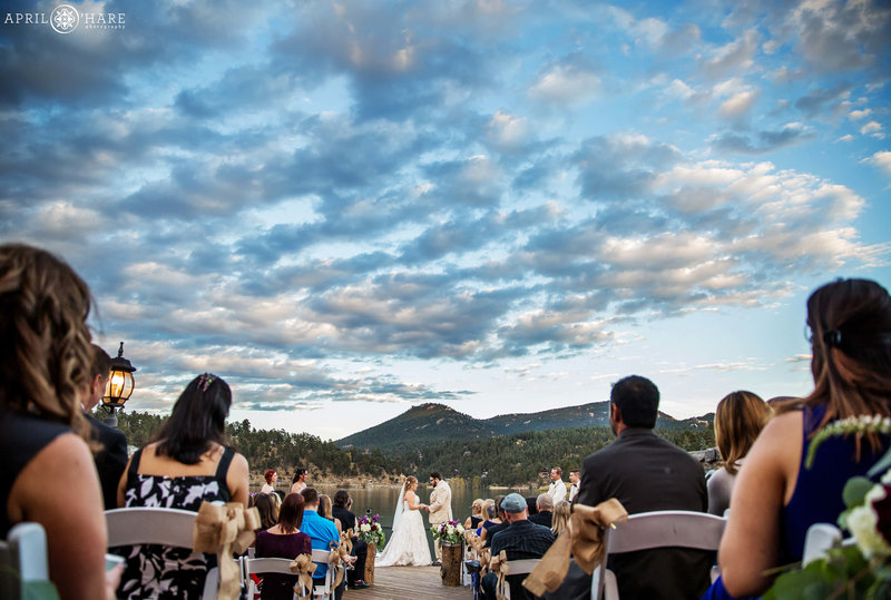 Beautiful sunset wedding ceremony on the outdoor deck of Evergreen Lake House in Colorado