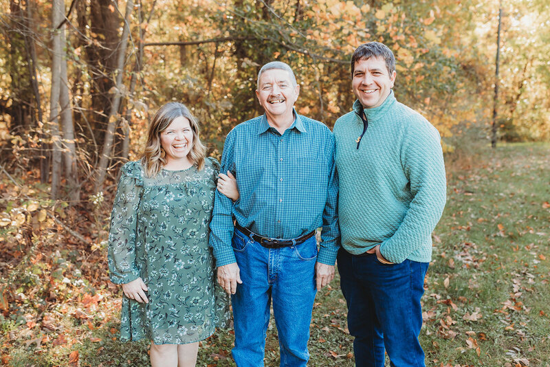 mom, dad, and little boy holding hands walking while dad carries little girl 