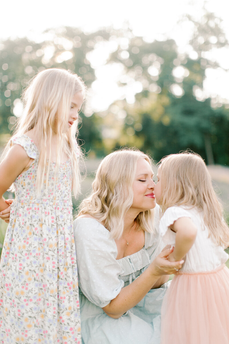 Husband kissing wife's head while she holds her newborn son