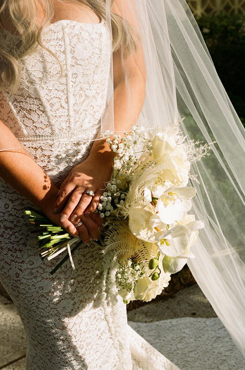 Modern white bridal bouquet with orchids, baby’s breath, and ferns, designed for a luxe wedding by The Eventful Gals.