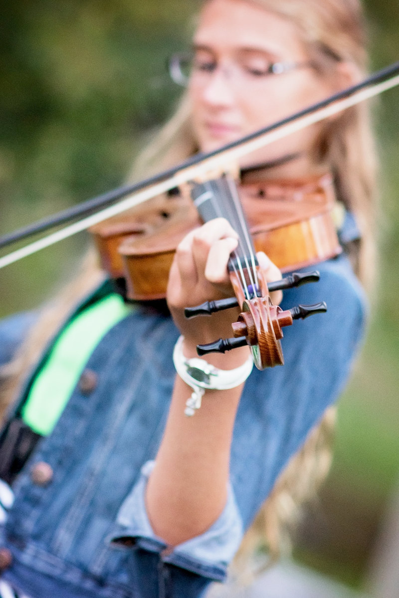Detail picture of a senior playing the violin.