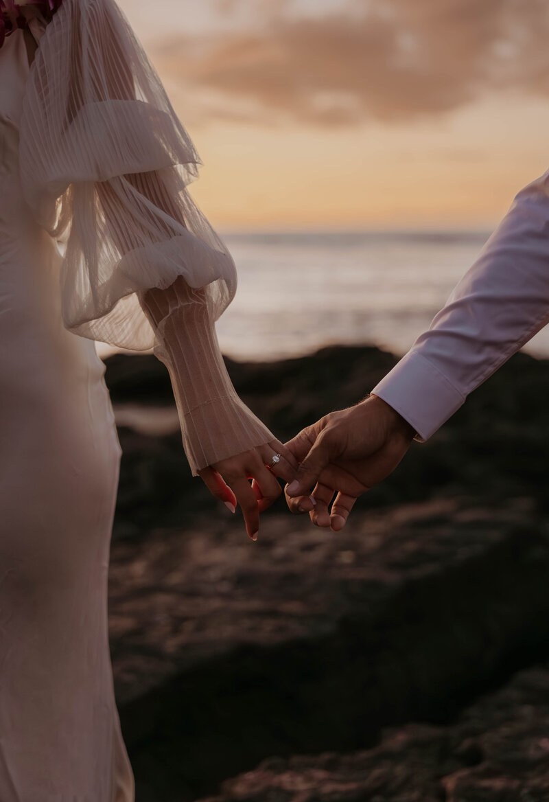 destination elopement photography  in hawaii bride and groom holding hands eloping on the beach