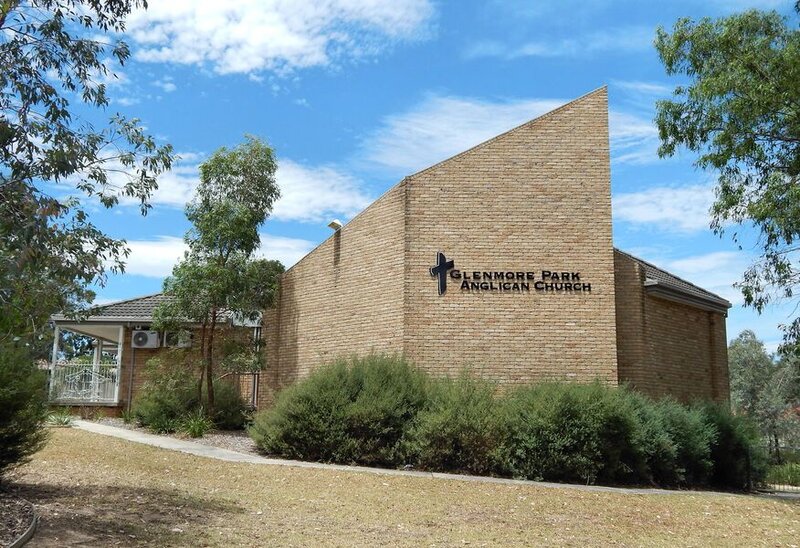 Exterior view of Glenmore Park Anglican Church in NSW, refurbished by Serlana Construction, featuring sandstone architecture and surrounding greenery.