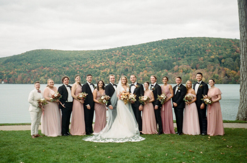 A bride and groom stand with their wedding parties