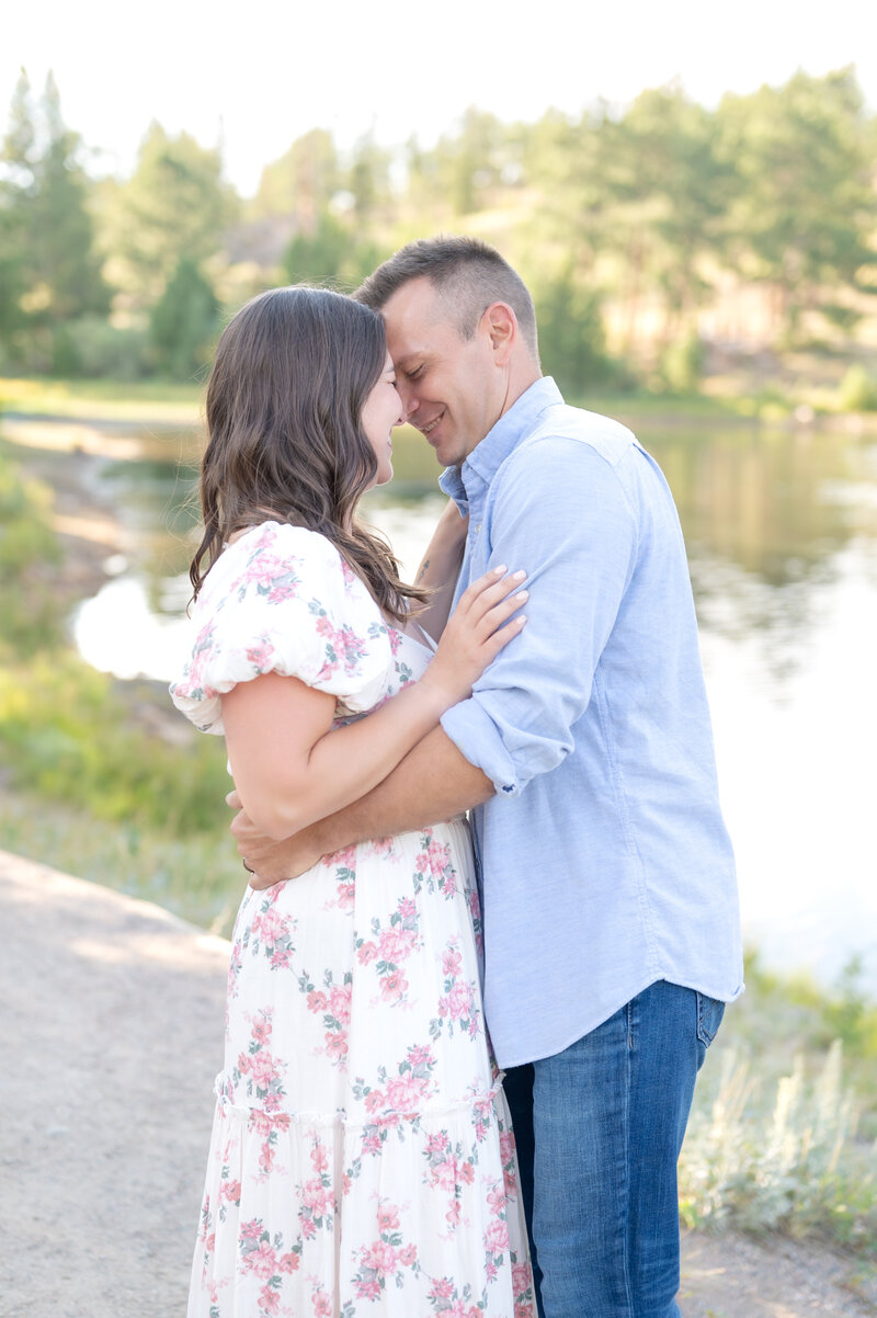 Couple leaning in for close hug while smiling and laughing together