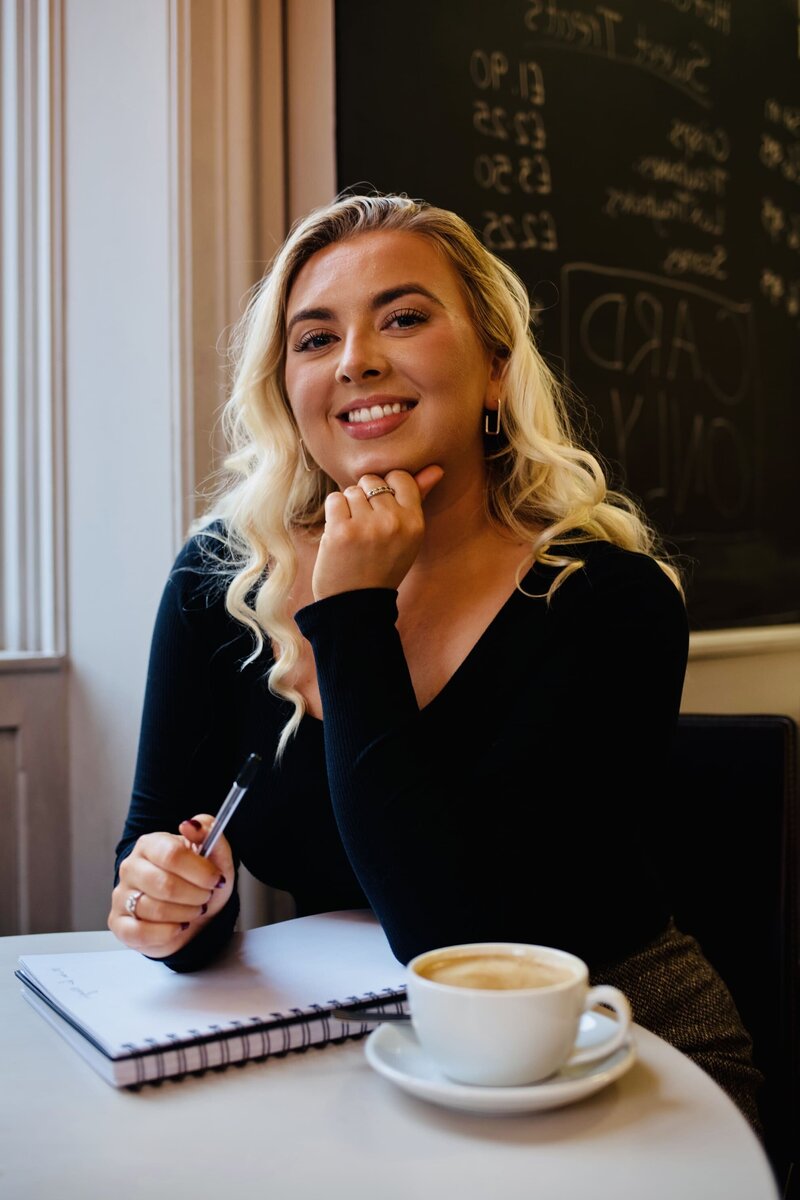 Copywriter for website Aoibh Johnson smiling at camera with a coffee