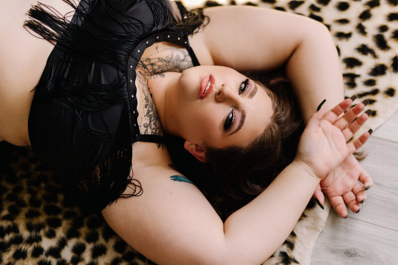 Confident woman posing on a leopard rug during a boudoir photoshoot in Orlando studio