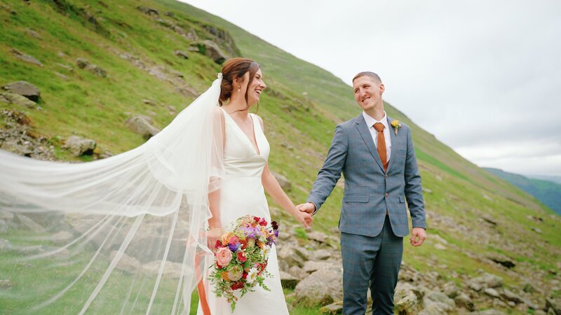 Bride and groom stood in the mountains of the lake district  after being married at Cragwood Country House Hotel taken by wedding videographer Anthony Horseman
