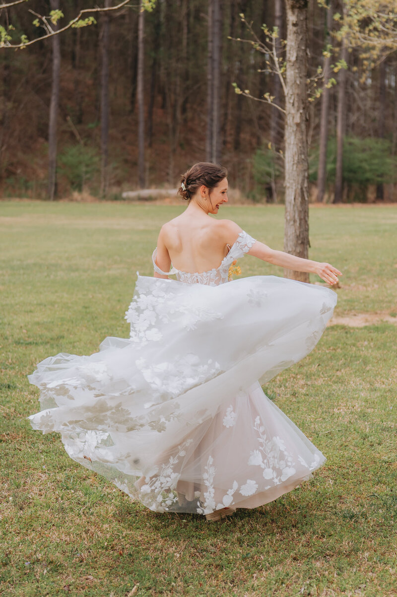 A person twirls in their wedding dress outdoors