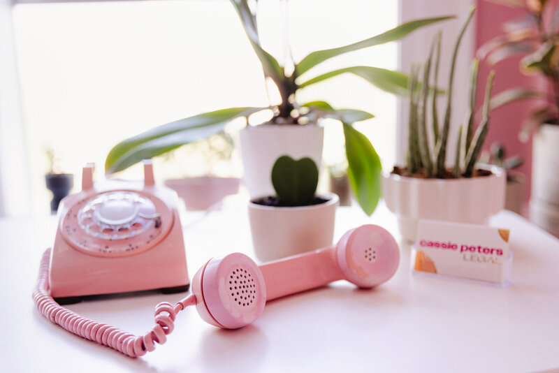 A phone and plants on a desk, representing the office of Cassie Peters Legal, a business lawyer in Eugene. 