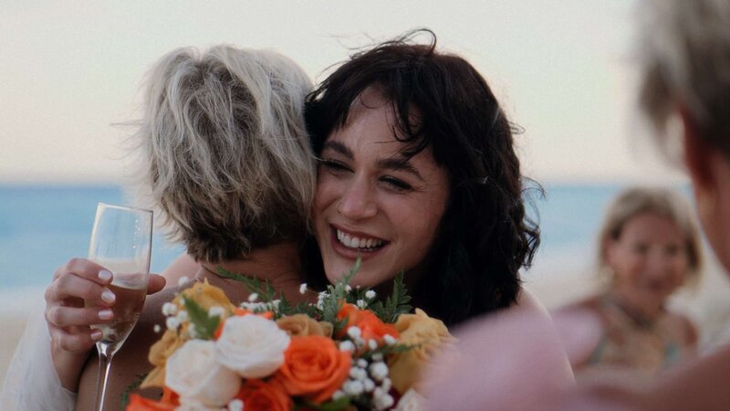 Bride embracing a friend after the ceremony on an Isla Mujeres beach.