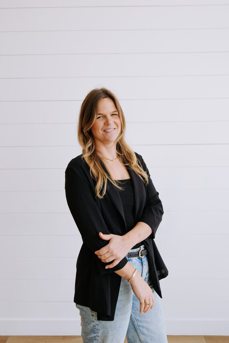 Event planner in cozy winter outfit and grey beanie smiling in snowy Banff forest – Rocky Mountain Wedding Collective