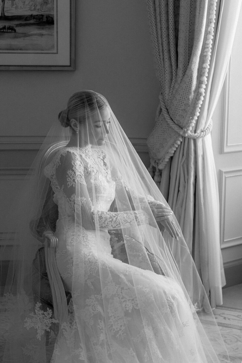 Black & white image of bride posing under her Monique Lhuillier vail.
