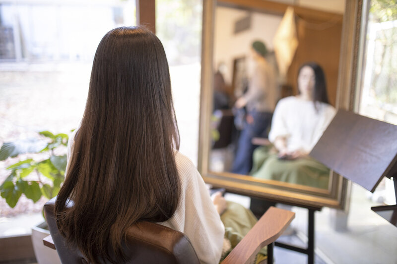 Brunette woman in salon chair with long hair