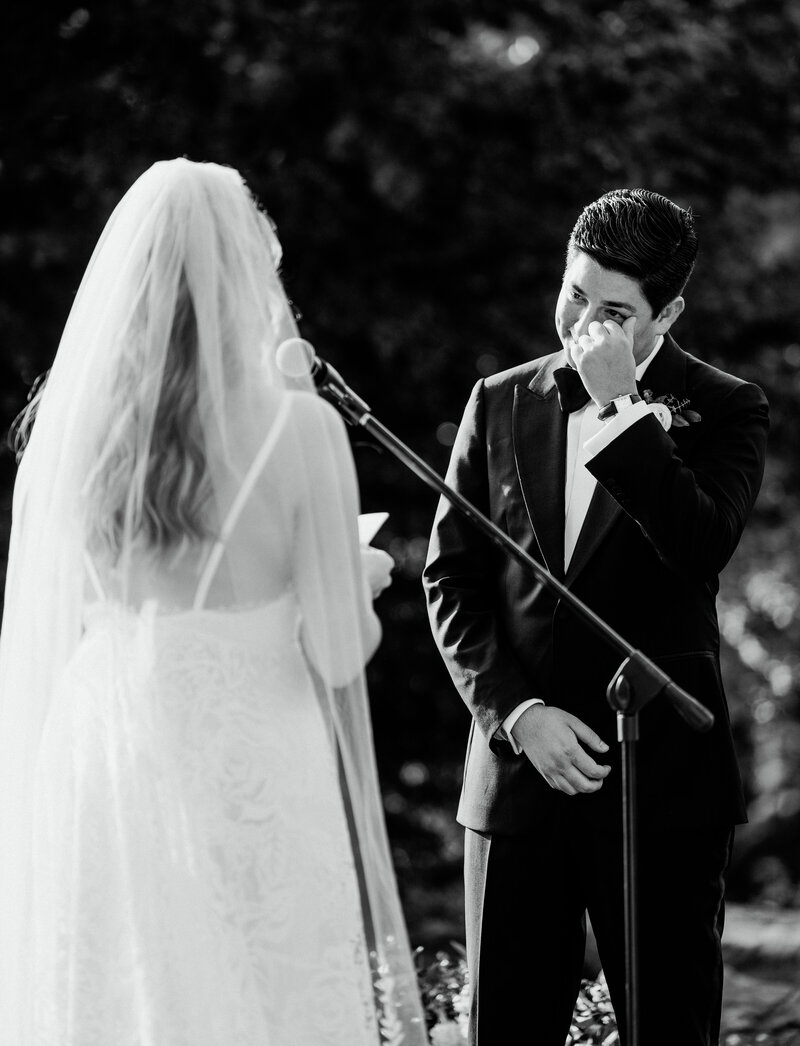 Groom wipes a tear from his eye while exchanging vows during beautiful ceremony at The Lyndhurst Mansion in Tarrytown, NY