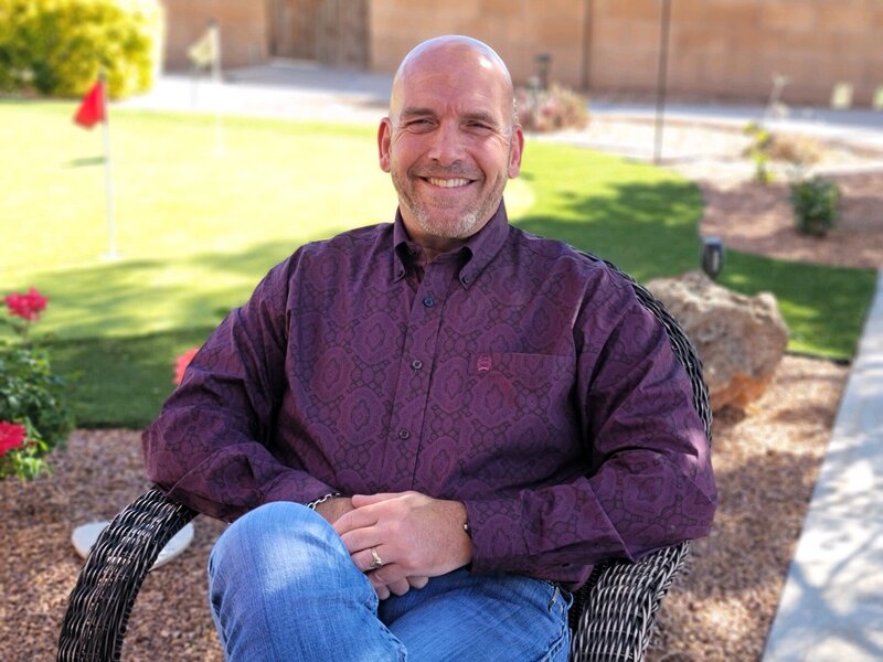 Dr. Gary Ritter smiling in chair outside