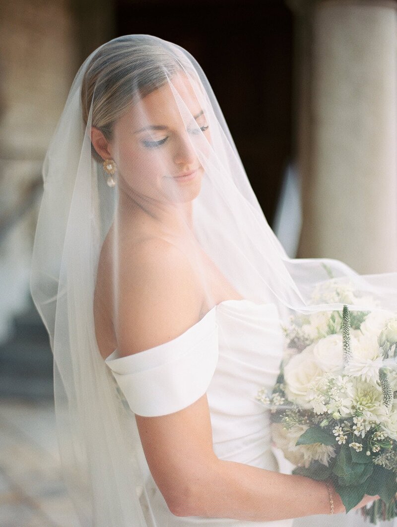 A bride poses with her veil over her and her bouqet at the United Methodist Church in Asheville, North Carolina