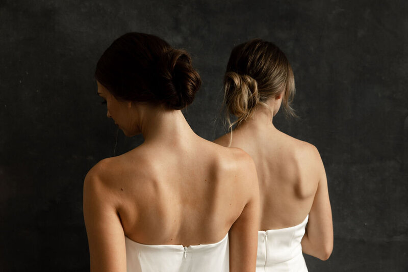 Two brides wearing strapless white dresses