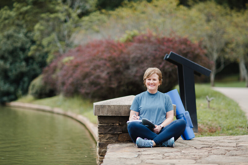 Woman in workout clothes sitting cross legged outside