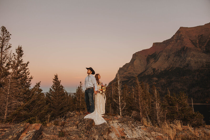 bride and groom posing on mountain
