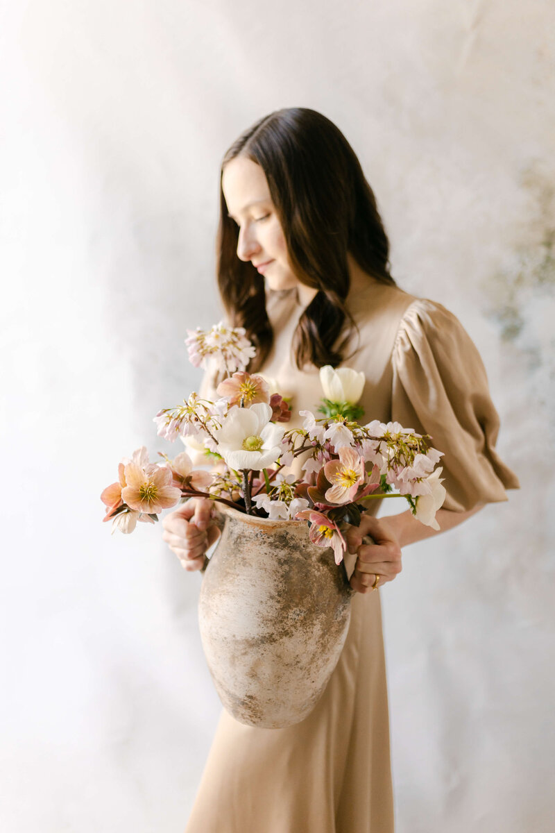 woman holding vase of flowers