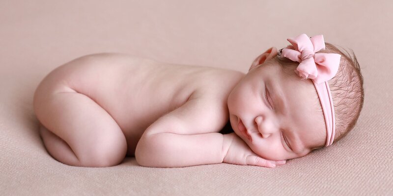 Sleeping newborn girl pose