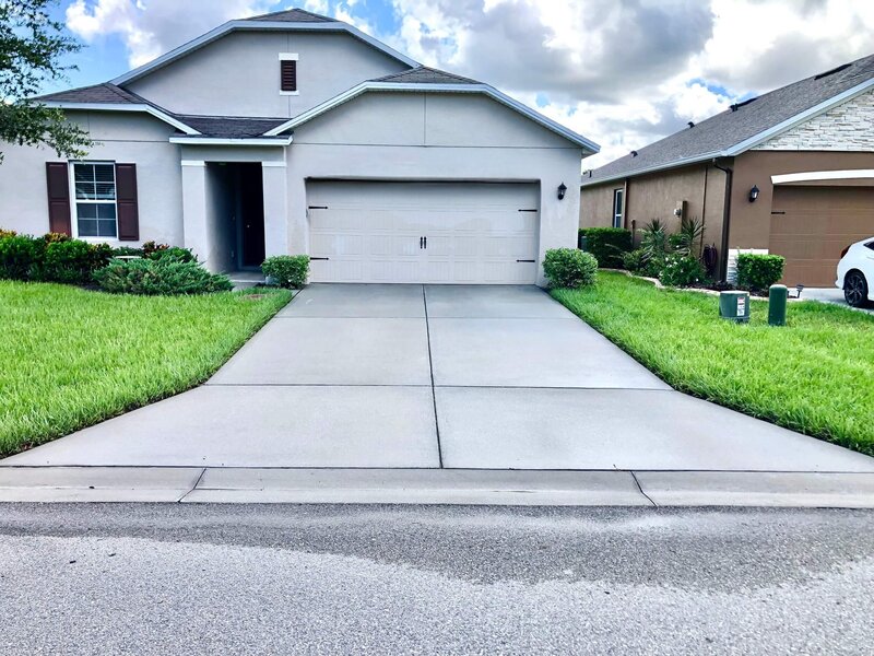 Before and after of a driveway being pressure washed for curb appeal
